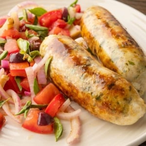 Two links of fish sausage, grilled and ready to eat.