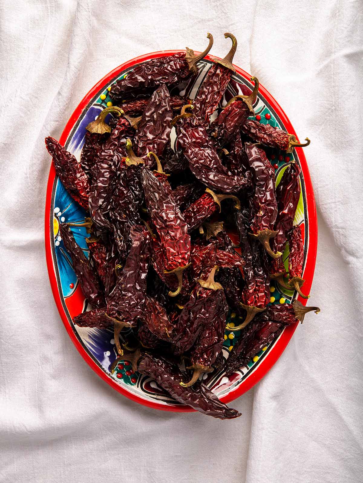 Chipotle peppers in a bowl on a kitchen cloth. 