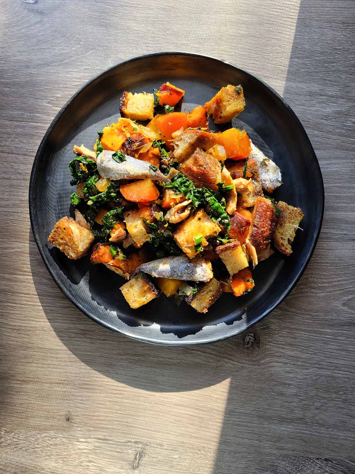 A plate of panzanella di mare done as a winter panzanella, in the fading light of November. 