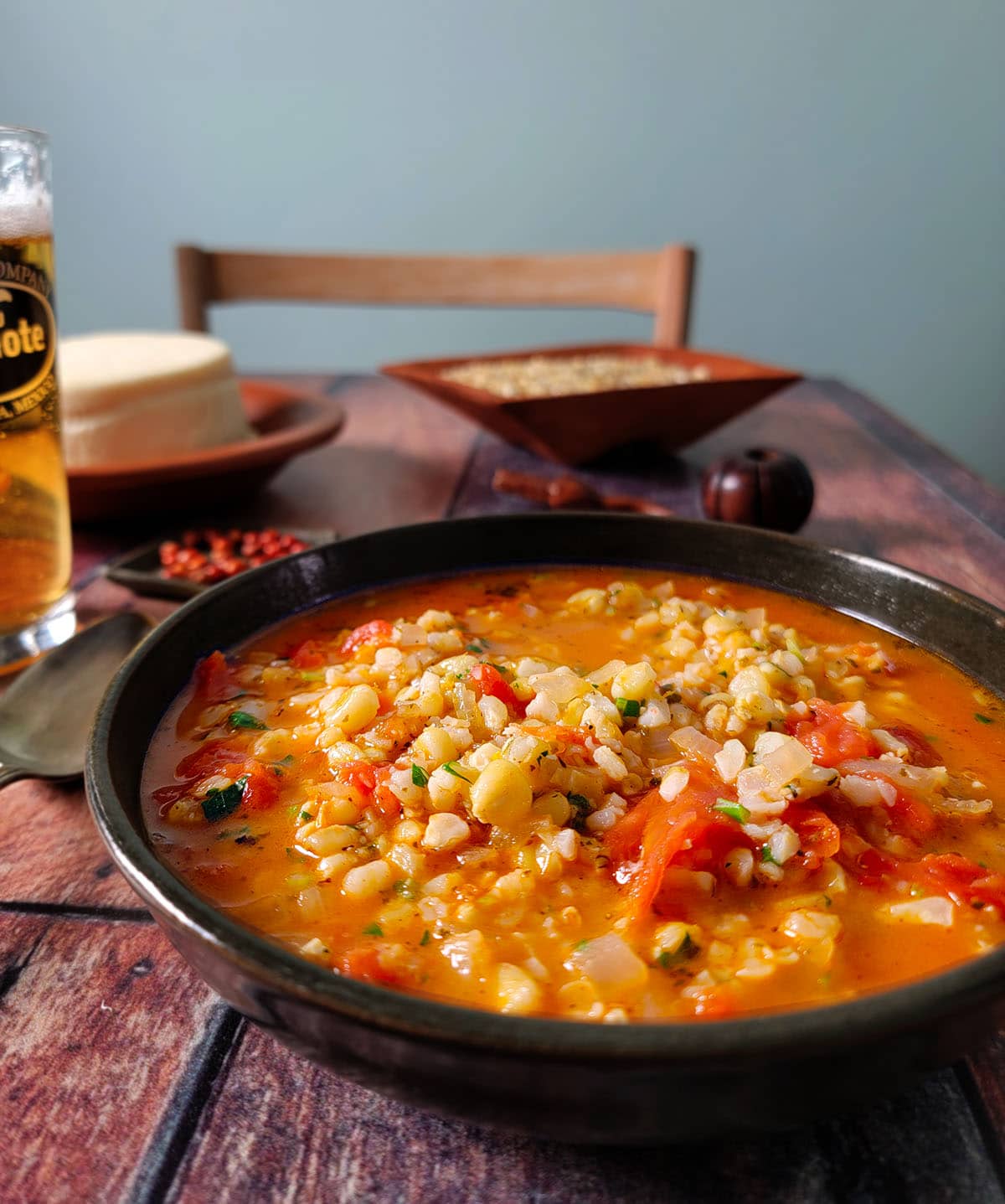 A bowl of chacales soup on a wooden table. 