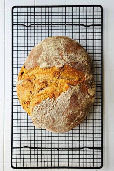 A light rye bread cooling on a rack.