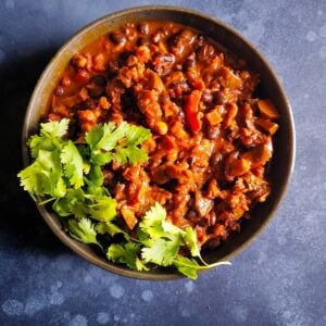 A bowl of mushroom chili with cilantro garnish.