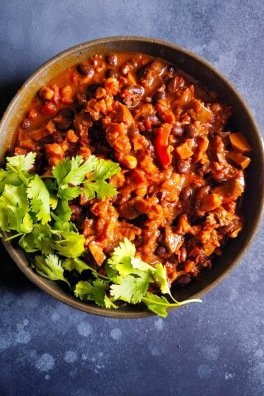 A bowl of mushroom chili with cilantro garnish.