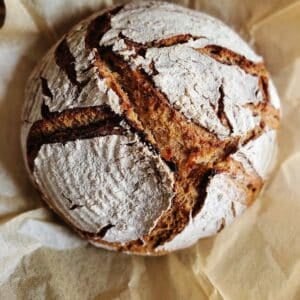 A loaf of rye sourdough bread cooling.