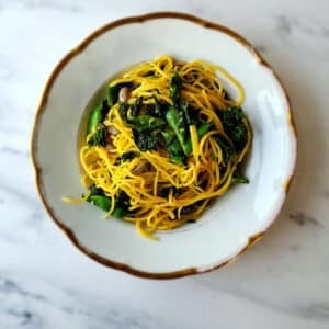 A bowl of tajarin pasta with beans and greens.