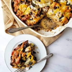 A portion of sausage strata on a plate, with the casserole dish nearby.