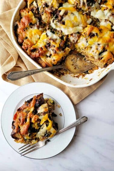 A portion of sausage strata on a plate, with the casserole dish nearby.