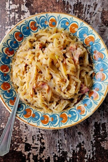 A bowl of German sauerkraut with bacon and applesauce, a great side dish.