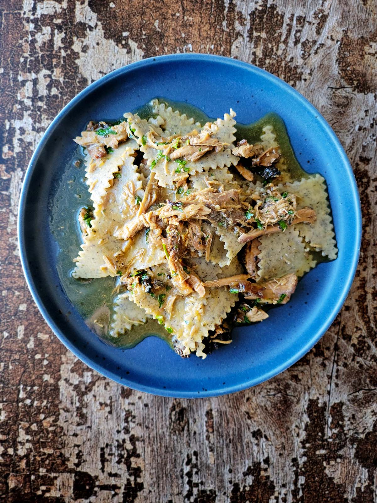 A plate of buckwheat pasta, blecs, with a chicken and onions sauce. 