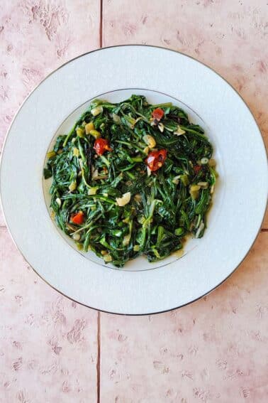 A sauteed dandelion greens recipe on a white plate.