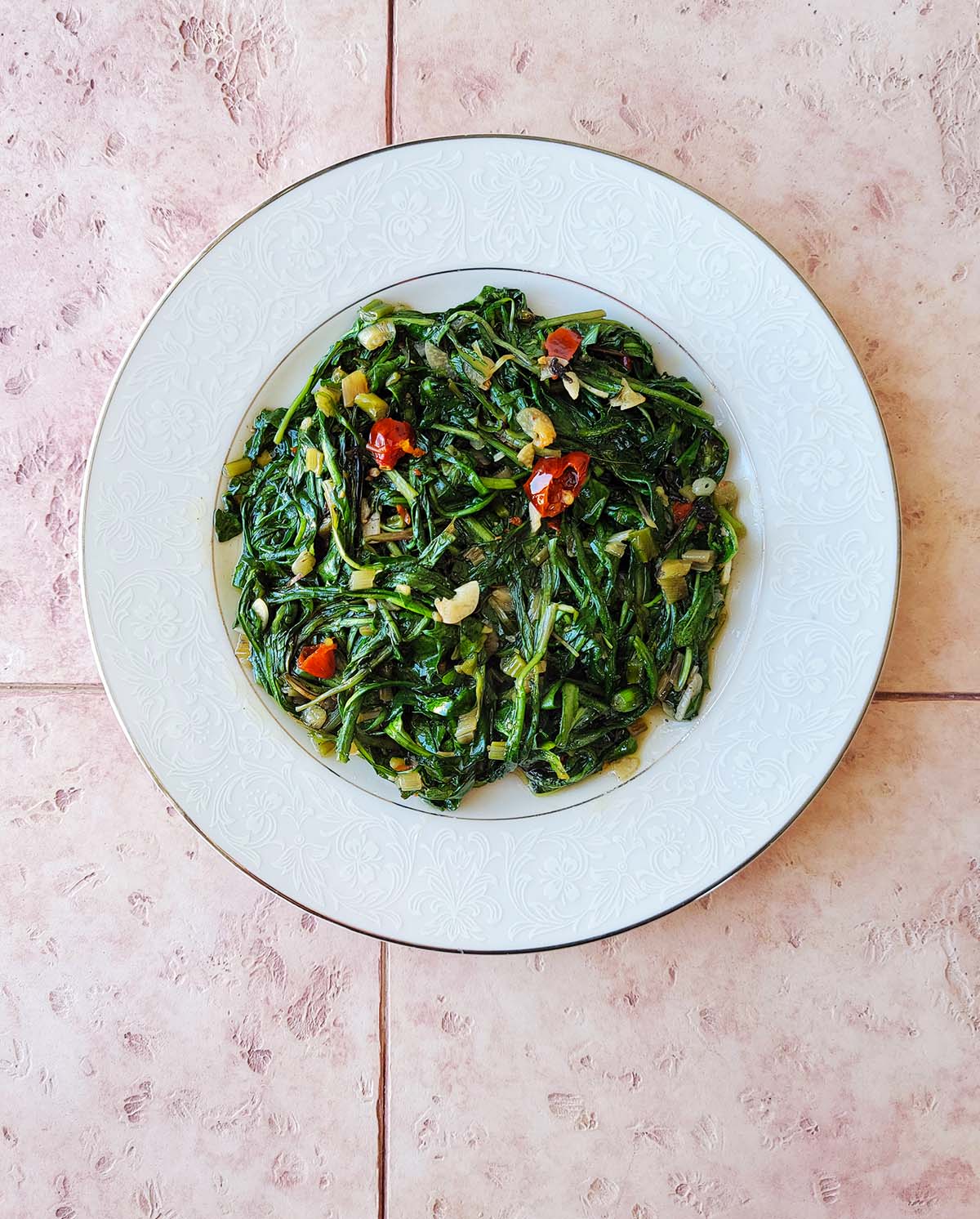 A sauteed dandelion greens recipe on a white plate. 