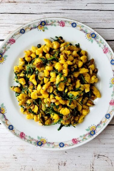 A plate of squash spaetzle with greens.