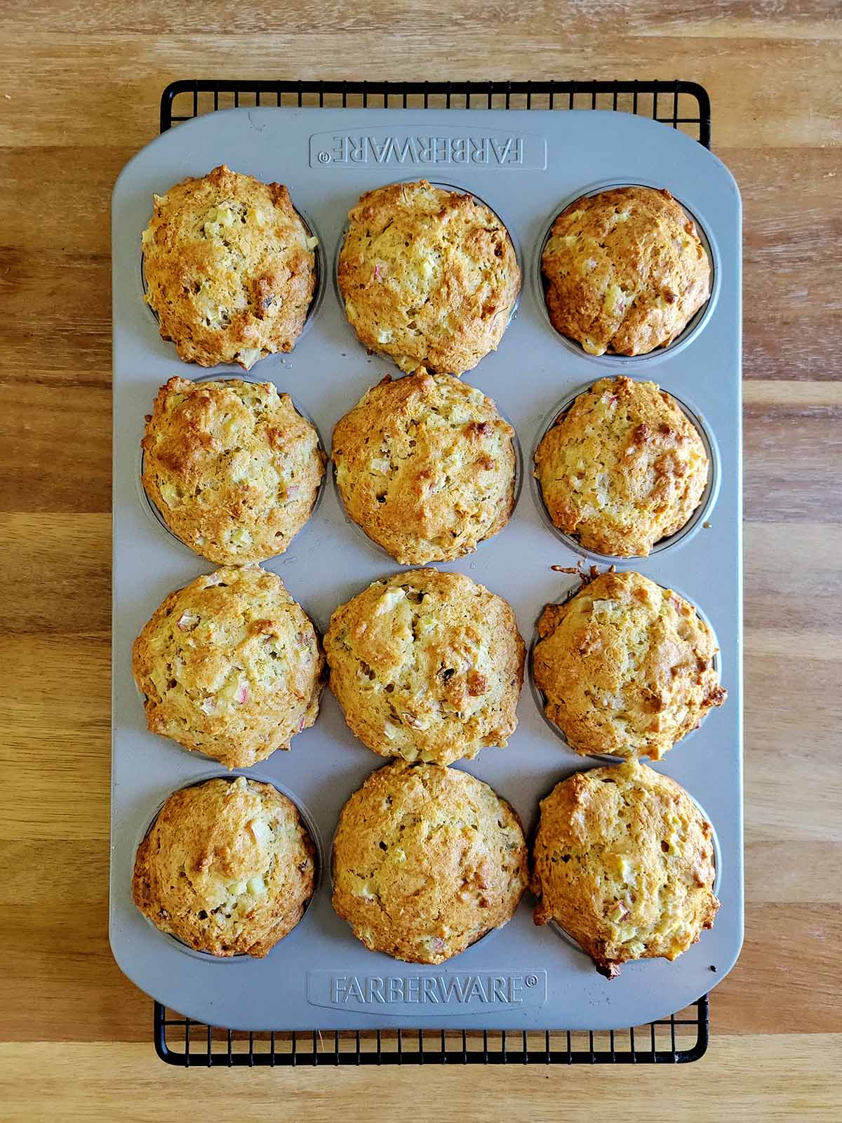 Rhubarb muffins in a muffin tin, cooling. 