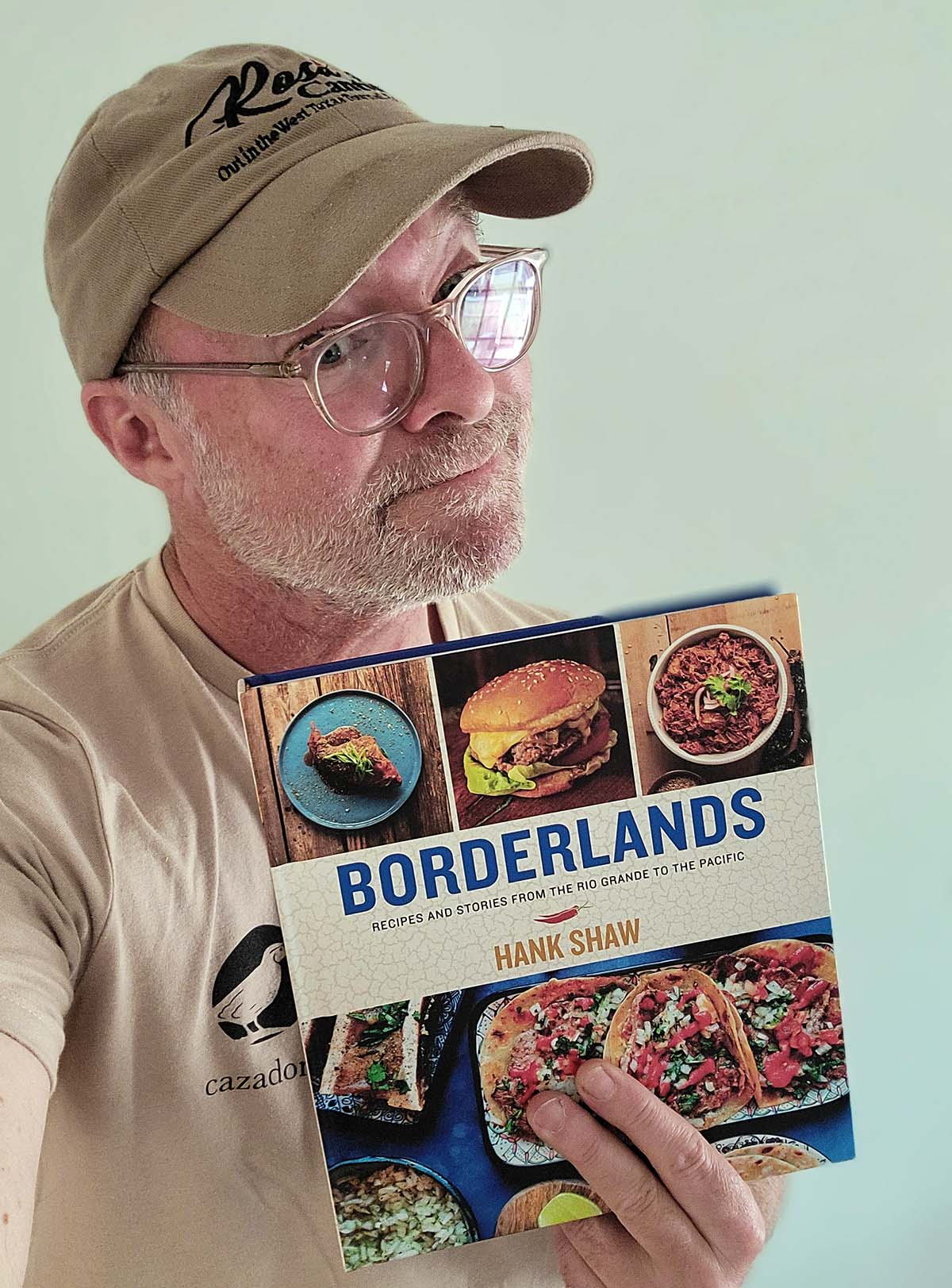 Hank Shaw holding a copy of his new book Borderlands.
